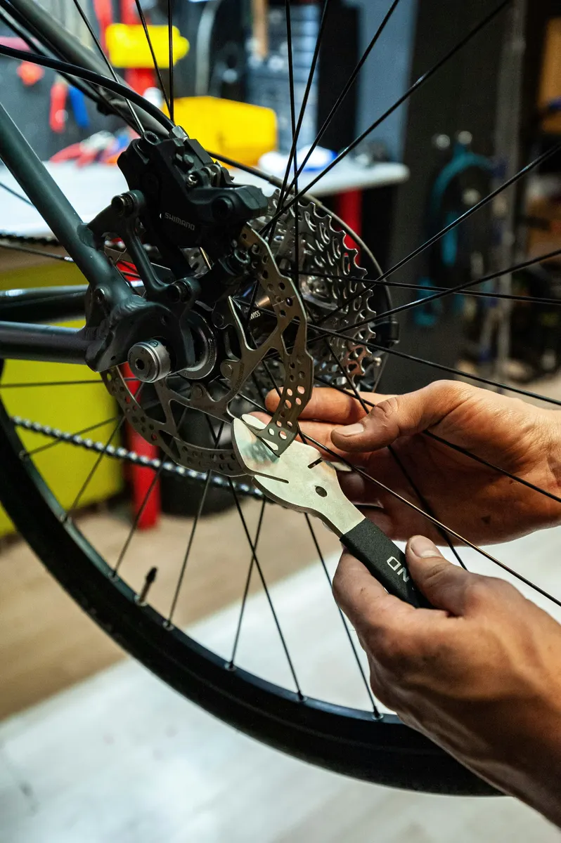 Bicycle mechanic repairing a bike and preparing a customer invoice