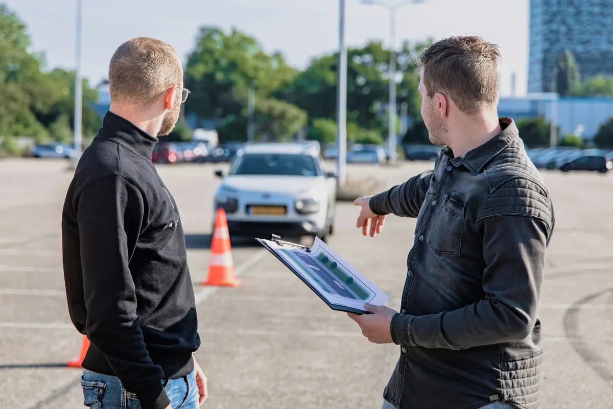 Driving instructor providing a driving lesson and preparing a pupil invoice