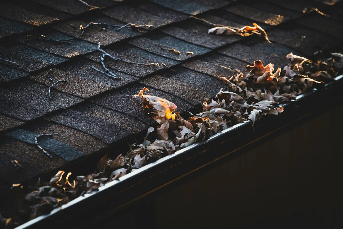 Contractor completing gutter installation and repair work at a property