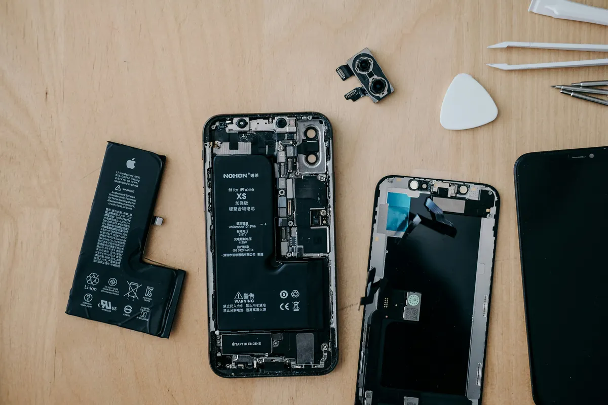 Phone repair shop technician working on a smartphone and recording repair charges