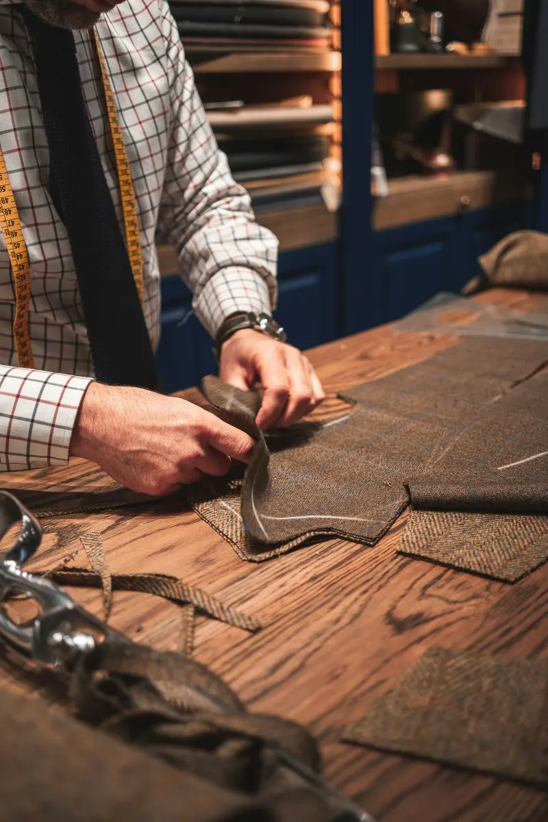 Tailor working on clothing alterations and preparing a customer invoice